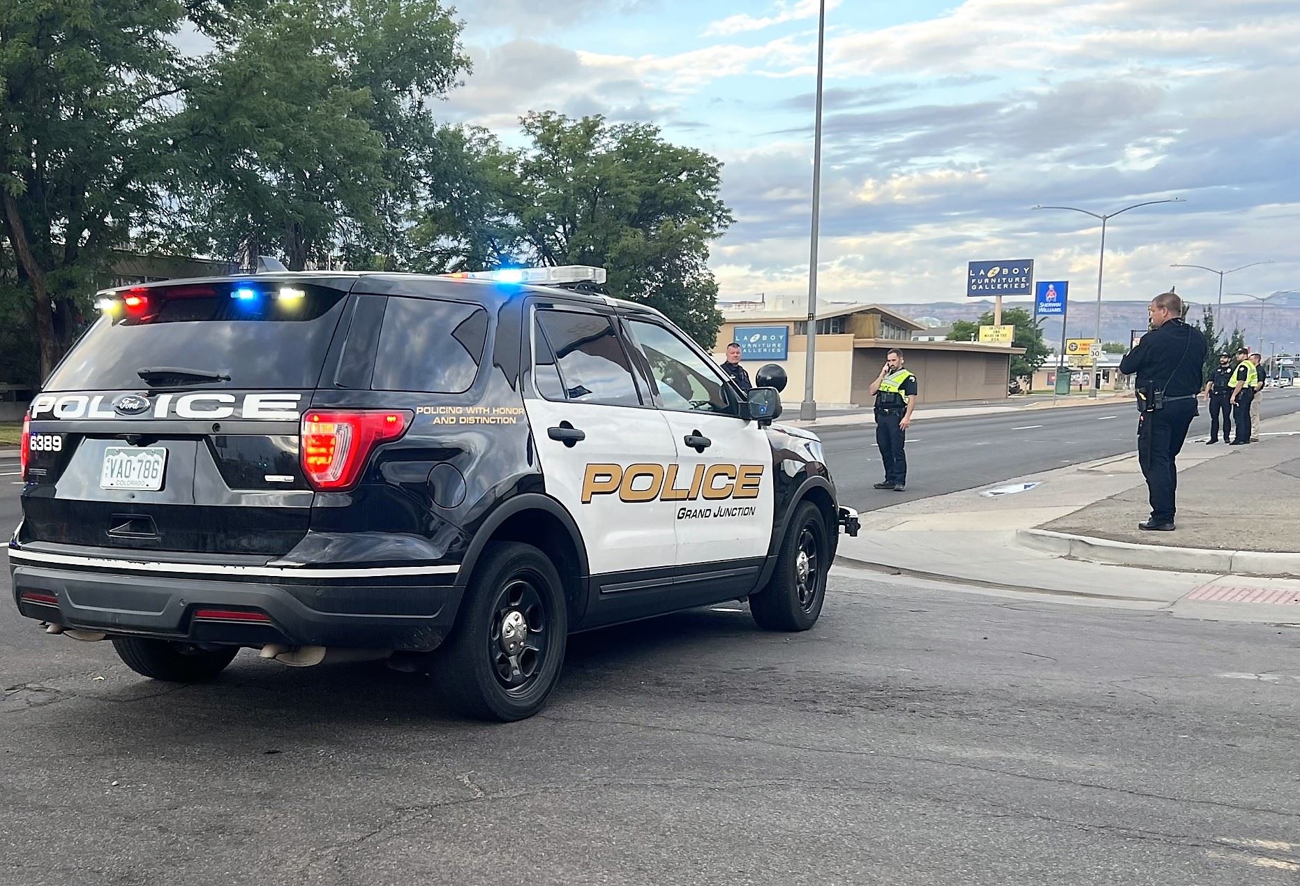 police vehicle at intersection with police officers nearby