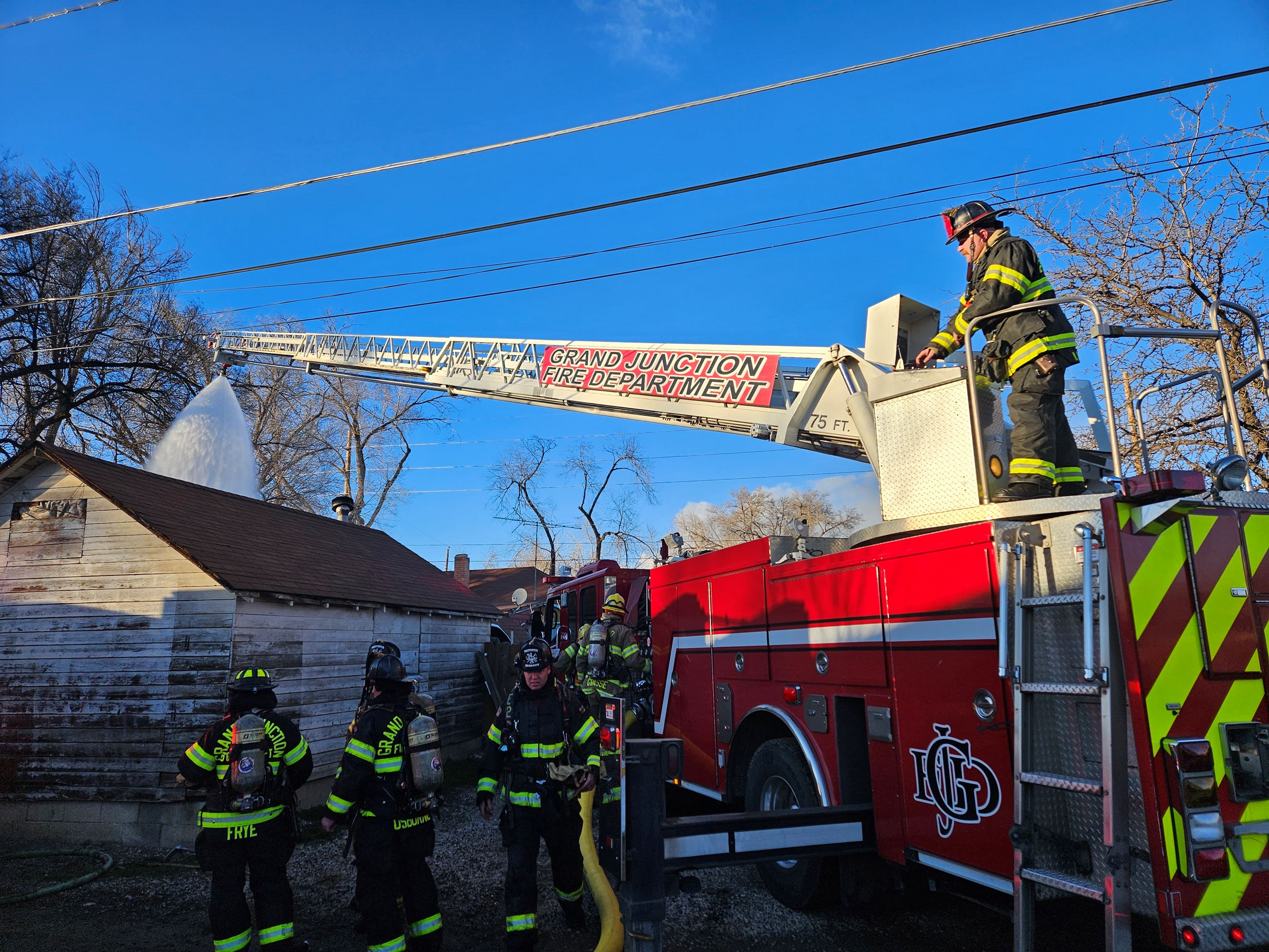 Truk 1 applies a large amount of water to a structure fire from above.