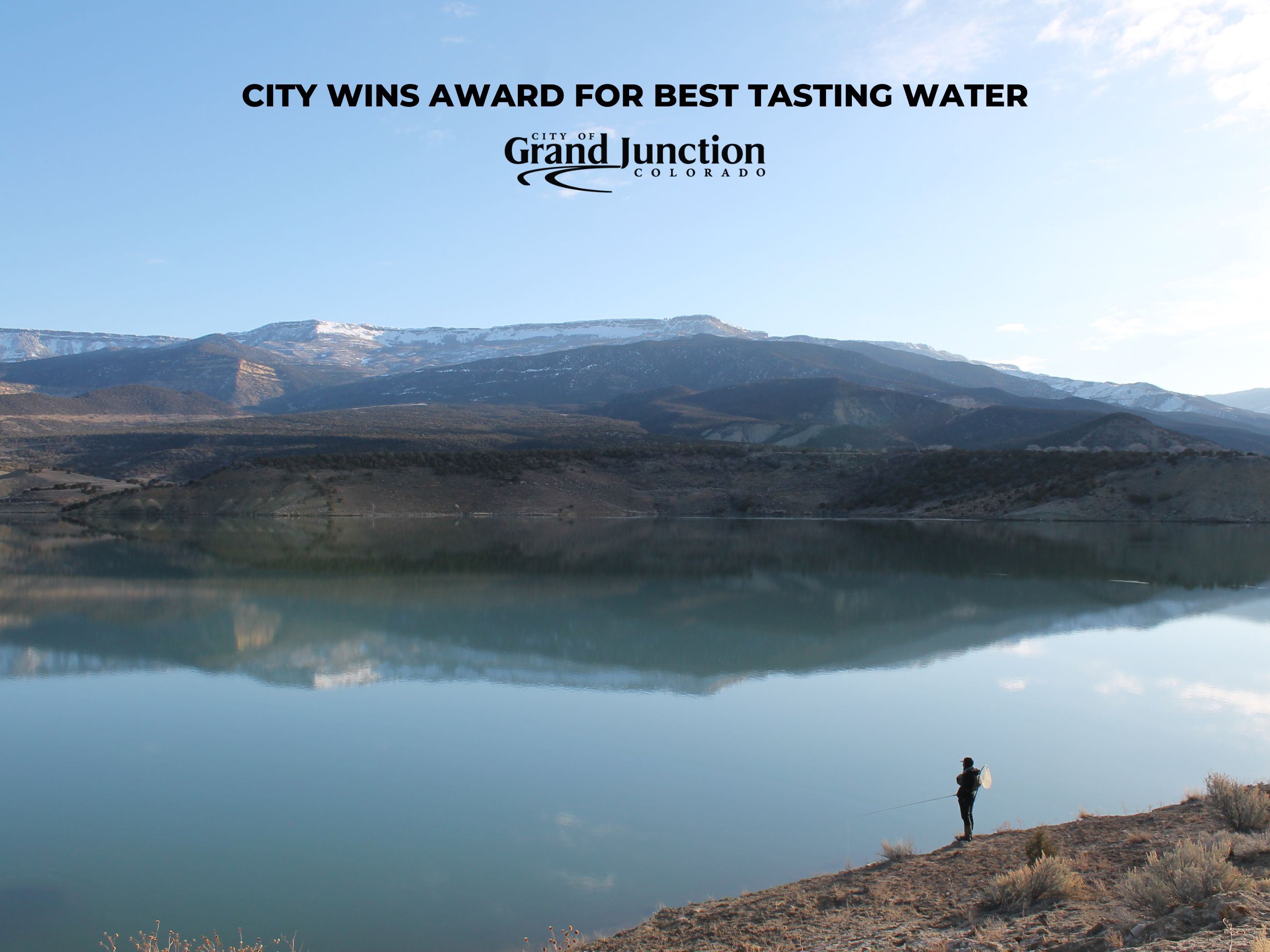 Lake in the mountains with person fishing. Text in image. 