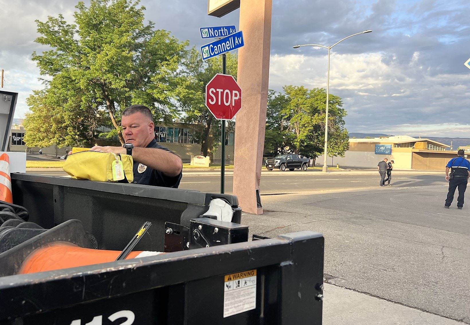 Police officer at traffic vehicle with other officers standing in intersection